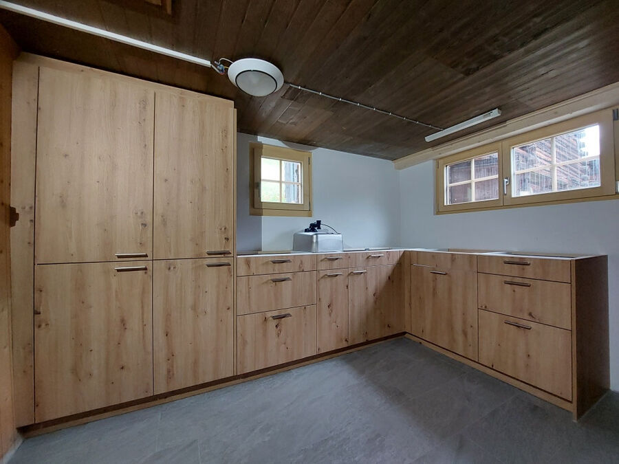 Küche mit Fronten in heller Eiche unter Holzdecke